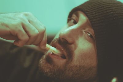 Close-up portrait of man holding cigarette