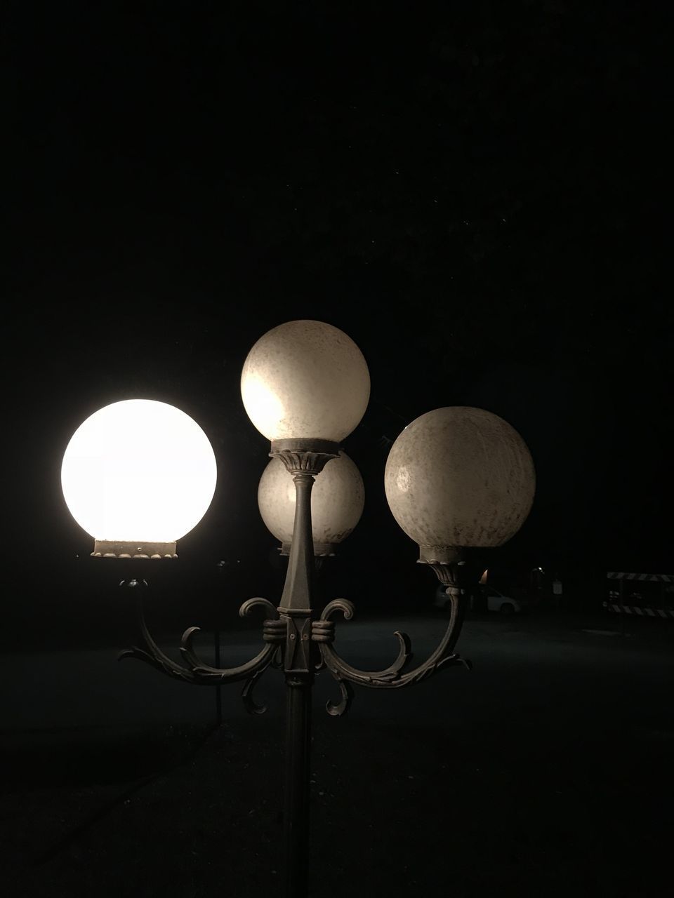 LOW ANGLE VIEW OF ILLUMINATED STREET LIGHT AGAINST DARK SKY