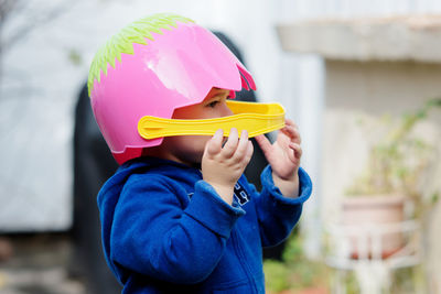 Cute toddler boy pretending to be a football player with an easter basket for a helmet