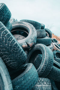 Stack of old abandoned car against sky