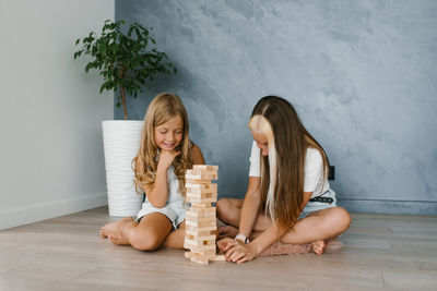 Caucasian sisters, the family spends time together on vacation in the living room of the house