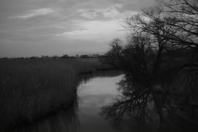 Scenic view of river against cloudy sky