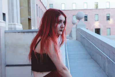 Portrait of beautiful young woman in front of building