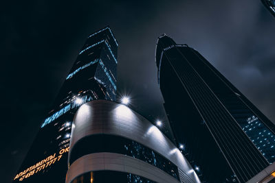 Low angle view of illuminated skyscrapers against sky at night