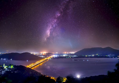 Scenic view of illuminated sea against sky at night