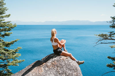 Woman looking at sea against sky