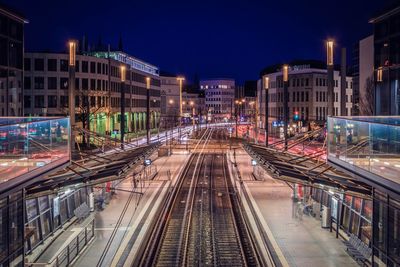 High angle view of railroad tracks amidst buildings in city at night