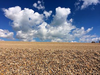 Scenic view of beach against cloudy sky