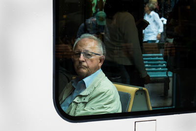 Portrait of man with reflection on window