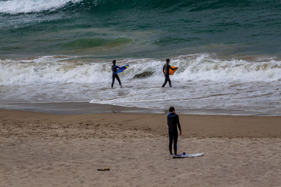 People with surfboard walking on beach