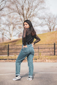 Portrait of young woman standing on road in city