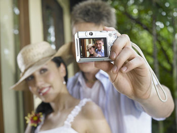 Close-up of couple taking selfie through camera