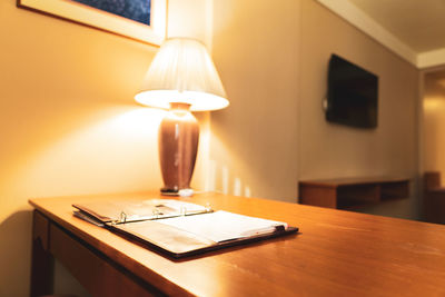 Close-up of illuminated lamp on table at home