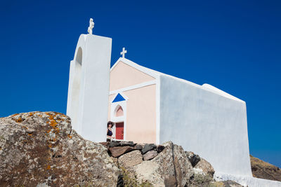 Low angle view of cross on rock against sky