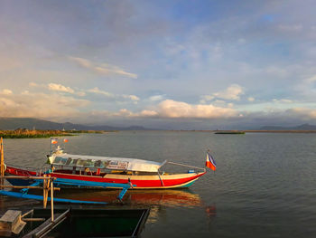 Fishing boats moored in sea against sky