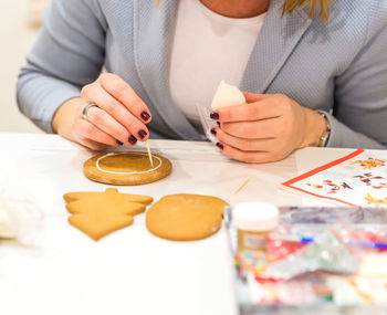 Midsection of woman holding ice cream on table