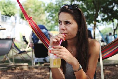 Portrait of young woman drinking glass