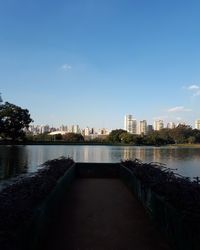 Modern cityscape by river against sky