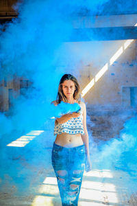 Portrait of young woman holding smoke bomb