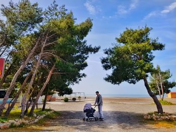 Man with baby stroller walking at beach