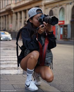 Full length of man photographing on street