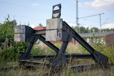 Old rusty metallic structure on field against sky