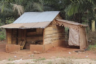 Old wooden house on field by trees