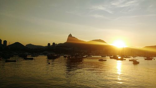 Boats in calm sea at sunset