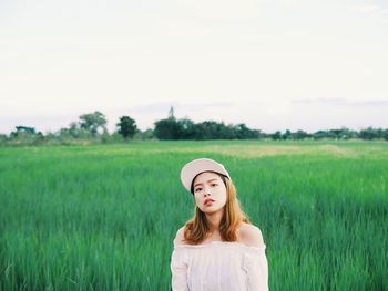 Portrait of beautiful young woman standing in farm