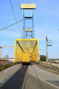 Yellow road against sky in city