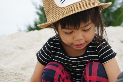 Close-up of cute girl wearing hat at beach