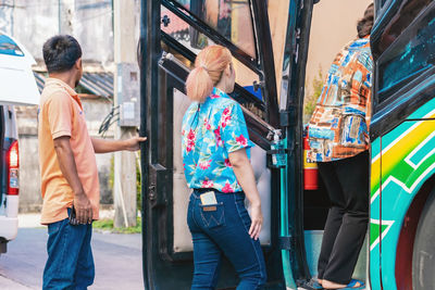 Rear view of people walking on street in city