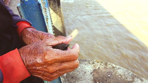 Cropped hands against sea