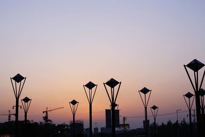 Street lights against sky during sunset