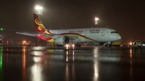 Illuminated airport runway against sky at night