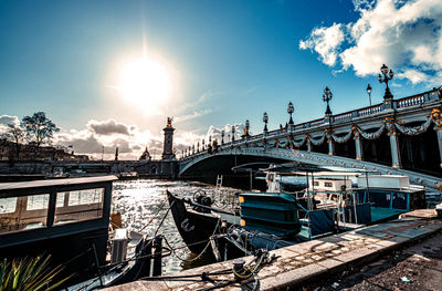 Bridge over river against cloudy sky