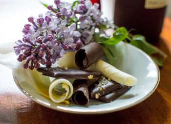 Close-up of flower with chocolate in plate on table