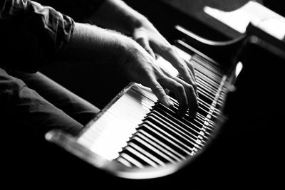 Midsection of pianist playing grand piano