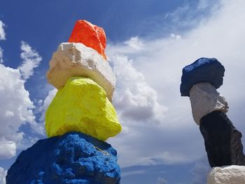 Low angle view of sculpture against rock against sky