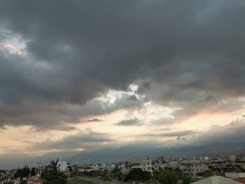 Buildings in city against sky during sunset