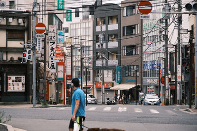 Man walking on street against buildings in city