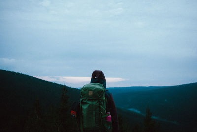 Rear view of woman looking at mountain against sky