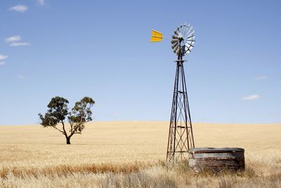 Traditional windmill on field against clear sky