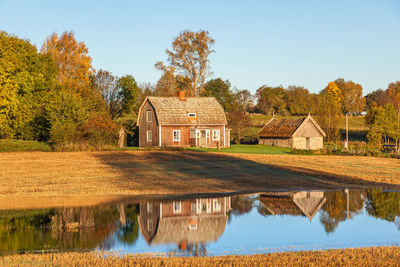 Old abandoned farmhouse with reflections in the water at the field