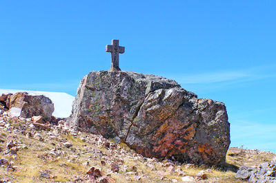 Low angle view of rock against clear blue sky