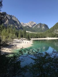 Scenic view of lake and mountains against clear blue sky