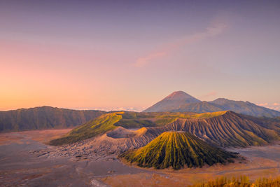 Scenic view of volcanic mountain against sky during sunset