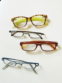 High angle view of eyeglasses on table against white background