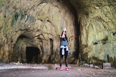 Woman standing on rock against wall