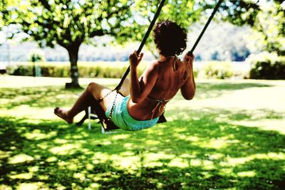 Woman enjoying on swing over field